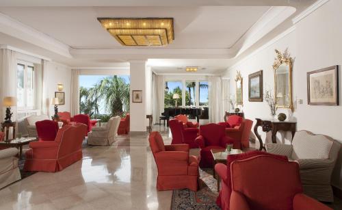 a waiting room with red chairs and tables at Grand Hotel Royal in Sorrento