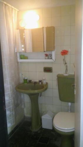 baño con lavabo verde y aseo en BONITO MONOAMBIENTE para dos Minimo 3 noches en Mar del Plata