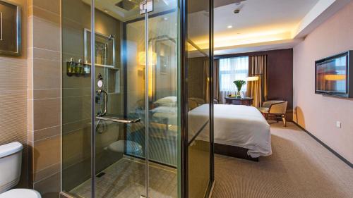 uma casa de banho com chuveiro e uma cama num quarto em SSAW Boutique Hotel Hangzhou East em Hangzhou