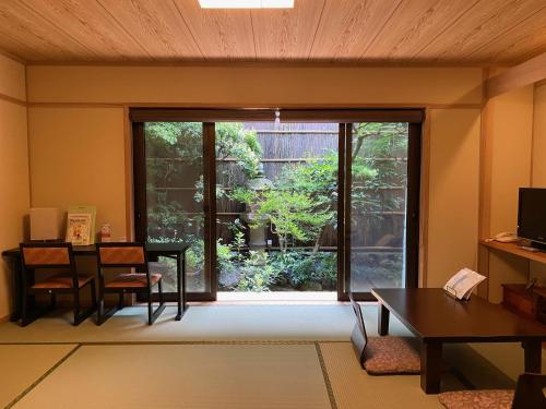 a living room with a large window and a table at Ryokan Sawaya Honten in Kyoto