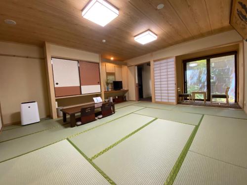 an empty room with a table and chairs and windows at Ryokan Sawaya Honten in Kyoto