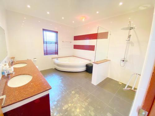Un baño con dos lavabos y una bañera. en Sunny3 villa Pattaya, en Ban Huai Yai