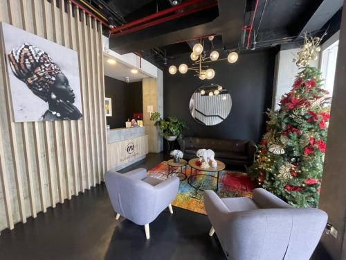 uma sala de estar com uma árvore de Natal e duas cadeiras em EM Budget Hotel Corferias Embajada Americana em Bogotá