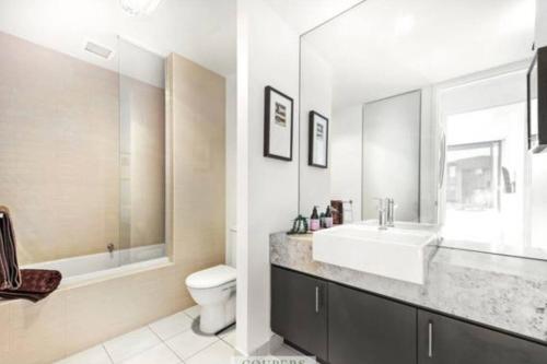 a white bathroom with a sink and a toilet at Moonah Links Apartment 45 Lovely 1 bedroom holiday home with heated pool in Fingal