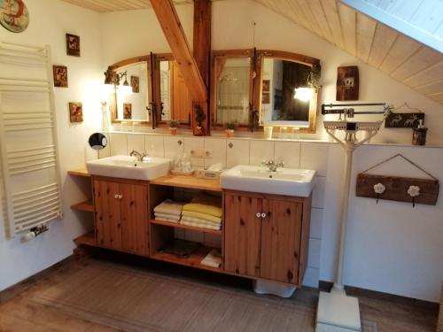 La salle de bains est pourvue de 2 lavabos et de 2 miroirs. dans l'établissement Ferienwohnungen Dopplerhof, à Piding