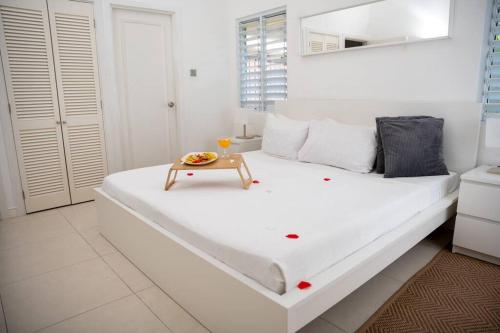 un dormitorio blanco con una cama con una mesa encima en House Of The Sun Vacation Home No 1, en Brissett Run