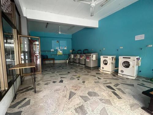 a laundry room with washing machines and a blue wall at Room101 in Wanna Apartment in Pattaya Central