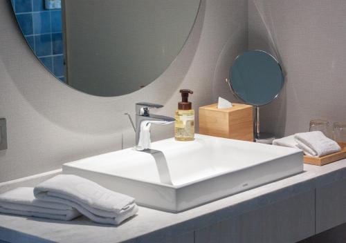 頭城的住宿－凱渡廣場溫泉酒店，浴室设有白色水槽和镜子