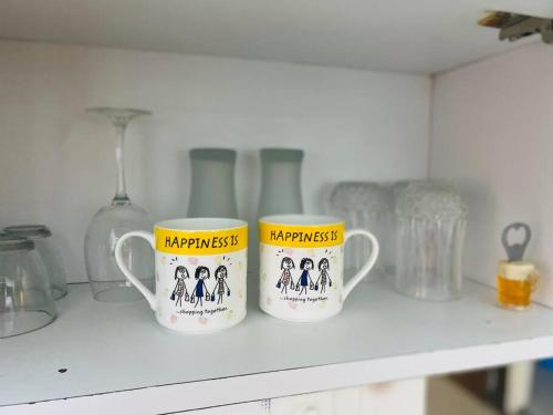two coffee mugs on a shelf in a kitchen at Lovely 2bed room AC apartment JP Nagar in Bangalore