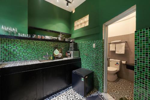 een groene badkamer met een wastafel en een toilet bij Ancient villa 108m2 duplex next to Hoan Kiem Lake! in Hanoi