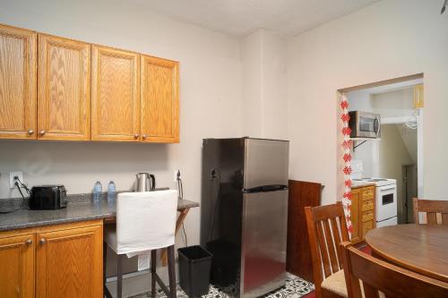 eine Küche mit einem Kühlschrank aus Edelstahl und einem Tisch in der Unterkunft Room #2 downtown ottawa in Ottawa