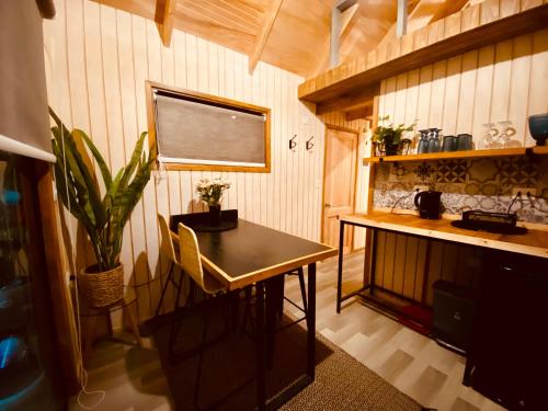 uma cozinha com uma mesa e um vaso de plantas em Colico Tiny Lodge - jacuzzi-Terraza em Catrico