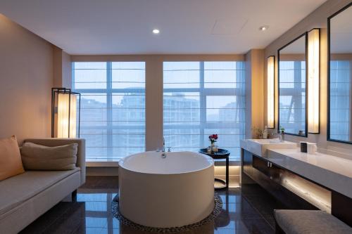 a bathroom with two sinks and a large tub at SSAW Boutique Hotel Hangzhou East - Free Self Service Laundry in Hangzhou