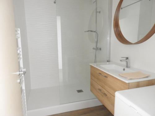 une salle de bain avec une douche avec un lavabo et un miroir dans l'établissement Appartement rénové front de mer aux Sables d'Olonne - FR-1-92-650, à Les Sables-dʼOlonne