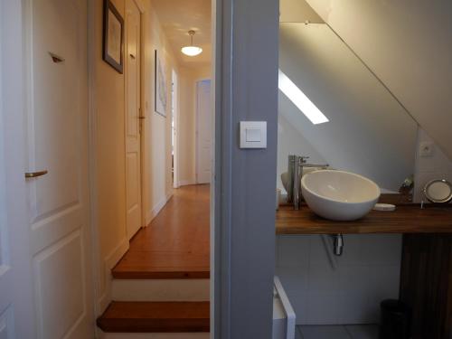 a bathroom with a sink and a hallway with a stairs at Maison Le Palais, 4 pièces, 6 personnes - FR-1-418-48 in Le Palais