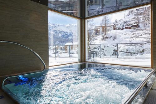 bañera de hidromasaje con vistas a una montaña nevada en La Vue Luxury Living Apartments en Zermatt