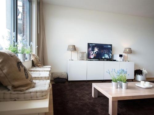 un soggiorno con divano, TV e tavolo di Sea view Apartment in Den Haag with Balcony a Scheveningen
