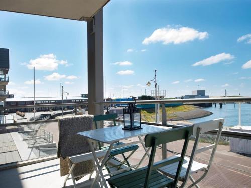 een tafel en stoelen op een balkon met uitzicht op het water bij Modern apartment in the harbor of Schevening in Scheveningen