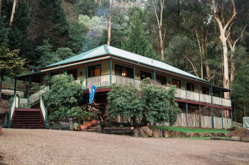 a house with a porch and stairs to it at Rustic Refuge Guesthouse in Kalorama