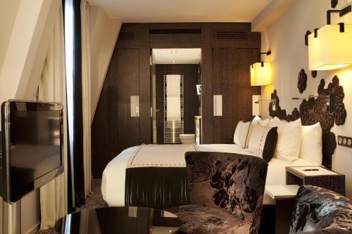 a hotel room with a bed and a chair at Les Jardins De La Villa in Paris