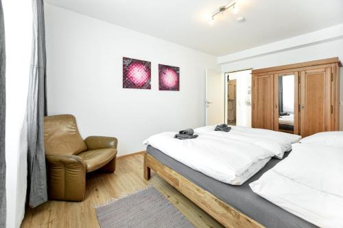 a bedroom with a bed and a chair at Ferienwohnung in der Sonnenstadt Lienz in Lienz