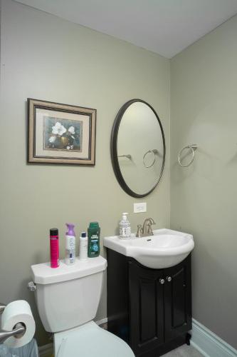 een badkamer met een toilet, een wastafel en een spiegel bij Room #4 Ottawa downtown in Ottawa