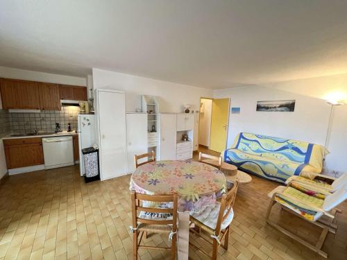 un salon avec une table et une cuisine dans l'établissement T2 cabine 6 pers avec piscine, proche plage, wifi - FR-1-702-18, au Cap d'Agde
