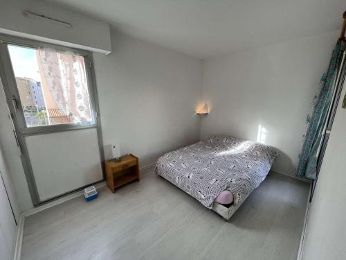 mała sypialnia z łóżkiem i oknem w obiekcie T2 cabine 6 pers avec piscine, proche plage, wifi - FR-1-702-18 w Cap d'Agde