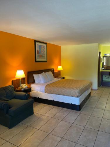 Habitación de hotel con cama y silla en Linder Motor Lodge, en Homer