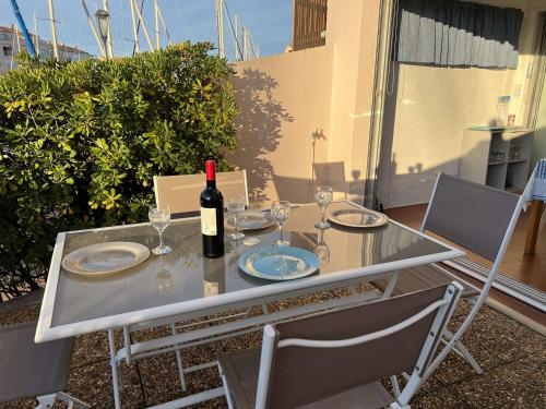 - une table avec une bouteille de vin et des verres dans l'établissement Studio cabine avec parking, lave-linge, lave-vaisselle, proche plage et commerces - FR-1-702-17, au Cap d'Agde