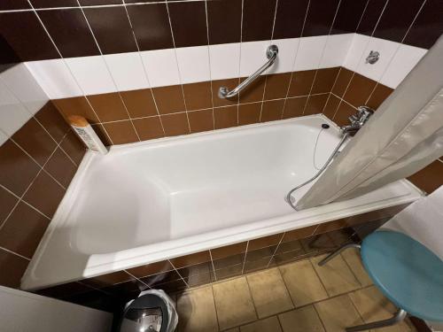 La salle de bains est pourvue d'une baignoire blanche et de toilettes. dans l'établissement Studio cabine avec parking, lave-linge, lave-vaisselle, proche plage et commerces - FR-1-702-17, au Cap d'Agde
