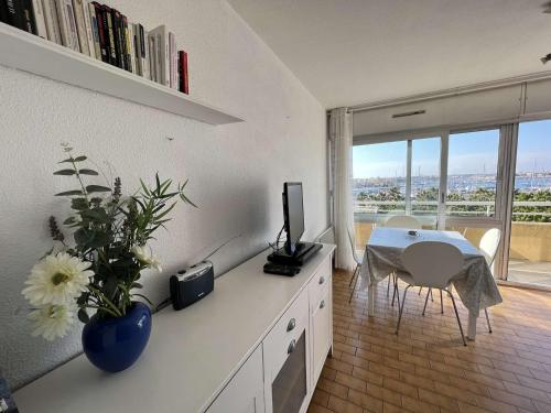 une cuisine avec une table, une télévision et une salle à manger dans l'établissement T2 avec ascenseur, lave-linge, parking et terrasse proche plage - FR-1-702-20, au Cap d'Agde