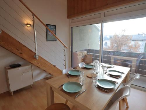 une salle à manger avec une table et une grande fenêtre dans l'établissement Les Gets - Appartement entièrement rénové - FR-1-623-331, aux Gets