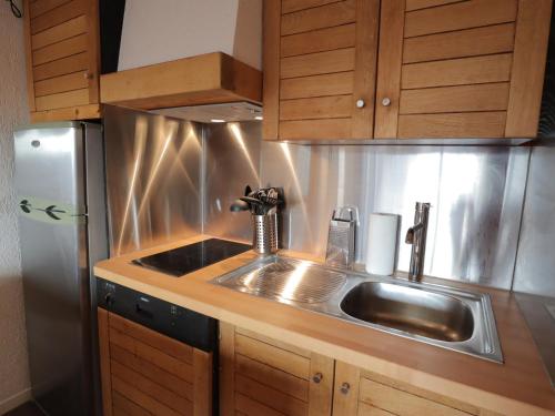 une cuisine avec un évier et un réfrigérateur dans l'établissement Les Gets - Appartement entièrement rénové - FR-1-623-331, aux Gets