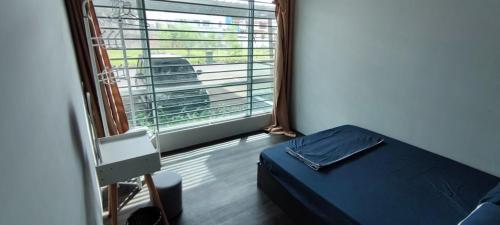 a bedroom with a bed and a large window at TAR HOMESTAY in Lahad Datu