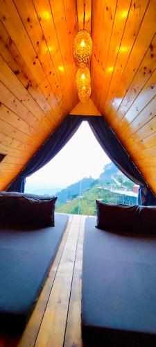 a large wooden table with pillows and a chandelier at Ban Mai Xanh homestay Tam Đảo in Vĩnh Phúc