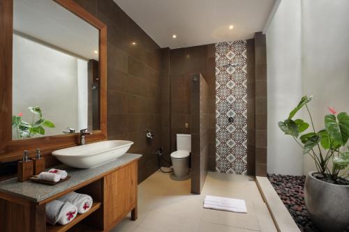 a bathroom with a sink and a mirror at MAHALONA BALI STAY in Canggu
