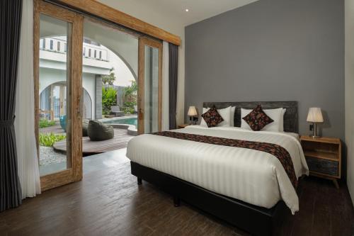a bedroom with a large bed and a large mirror at MAHALONA BALI STAY in Canggu