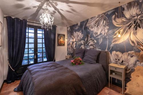1 dormitorio con 1 cama con papel pintado de flores en Bastide Aïna SPA et piscine, en Grasse