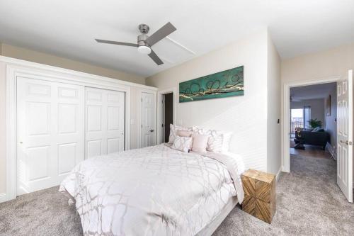 a white bedroom with a bed and a ceiling fan at Scenic Skyline View-Downtown in Cincinnati