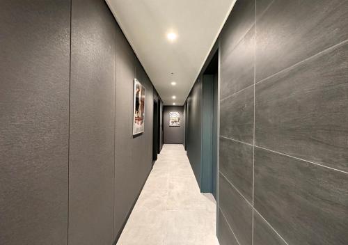 a hallway with gray walls and a long corridor at Y COLLECTION by UH FLAT OSIRIA in Busan