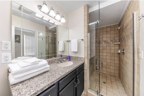 a bathroom with a sink and a glass shower at Scenic Skyline View-Downtown in Cincinnati