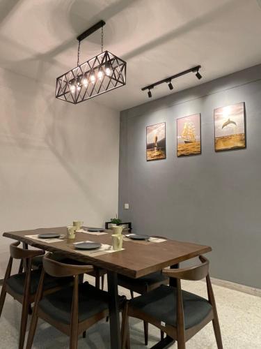 a dining room with a wooden table and chairs at 15Px 5BR V Jaccuzi Spa n KTV n Pool Table At Georgetown, USM n Lam Wah Ee Hospital -Kids pool no more in Gelugor