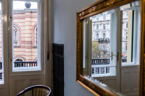a mirror in a room with a view of a building at Luxury Downtown 3 Bedroom Apartment by Synagoge with Beautiful View in Budapest