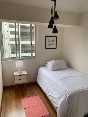 sypialnia z białym łóżkiem i oknem w obiekcie Hermoso apartamento con piscina Miraflores- Canvas w mieście Lima