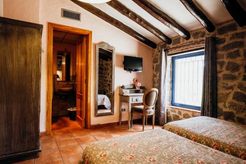 Alforja的住宿－Mas Fullat cottage, Alforja tarragona，一间卧室配有两张床和一张书桌。