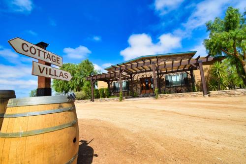 a wine barrel with a sign in front of a building at Peppertree Lane Ranch -- Seven-Acre Ranch in the Heart of Wine Country in Temecula