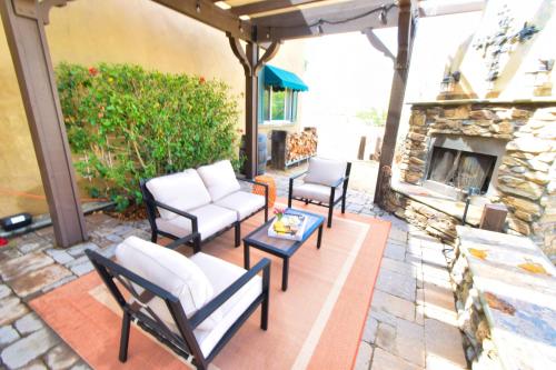 a patio with chairs and a stone fireplace at Peppertree Lane Ranch -- Seven-Acre Ranch in the Heart of Wine Country in Temecula