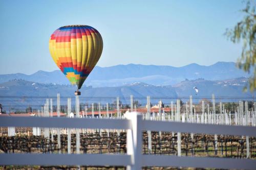 a hot air balloon flying over a white fence at Peppertree Lane Ranch -- Seven-Acre Ranch in the Heart of Wine Country in Temecula