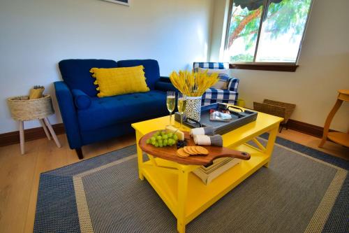 a living room with a yellow coffee table and a blue couch at Peppertree Lane Ranch -- Seven-Acre Ranch in the Heart of Wine Country in Temecula